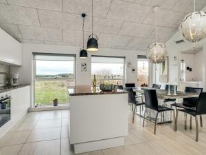 uma cozinha e sala de jantar com mesa e cadeiras em Holiday Home Eveline - 1-5km from the sea in NW Jutland by Interhome em Løkken