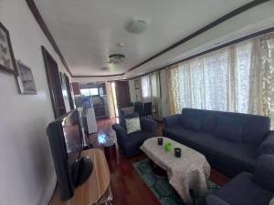 een woonkamer met een blauwe bank en een tafel bij Remarkable 1-Bed Apartment in Davao City in Davao City