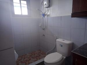 a bathroom with a toilet and a shower with a window at Remarkable 1-Bed Apartment in Davao City in Davao City