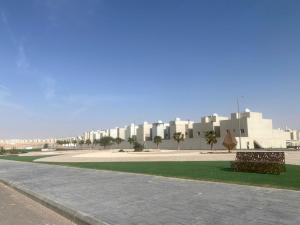 a park with two benches in front of a building at Riyadh Salman Villa فيلا in Riyadh
