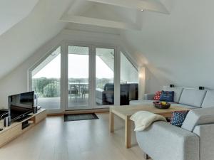 a living room with a couch and a tv at Holiday Home Skamhals - 700m from the sea in NW Jutland by Interhome in Blokhus
