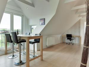 a room with a table and chairs in a attic at Holiday Home Skamhals - 700m from the sea in NW Jutland by Interhome in Blokhus