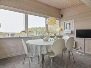 洛肯的住宿－Holiday Home Franja - 100m from the sea in NW Jutland by Interhome，一间带桌椅和电视的用餐室