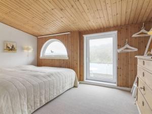 洛肯的住宿－Holiday Home Franja - 100m from the sea in NW Jutland by Interhome，一间卧室设有一张大床和一个窗户。