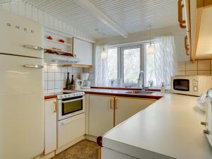 洛肯的住宿－Holiday Home Franja - 100m from the sea in NW Jutland by Interhome，厨房配有白色橱柜和白色冰箱。