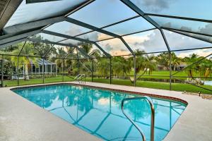 a large swimming pool with a glassconservatory at Waterfront Port St Lucie Home with Lanai and Pool in Walton