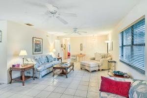 a living room with a couch and a table at Waterfront Port St Lucie Home with Lanai and Pool in Walton +17 photos