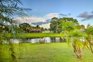 a park with a bench next to a lake at Waterfront Port St Lucie Home with Lanai and Pool in Walton