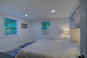 een witte slaapkamer met een bed en 2 ramen bij FERRY TALE LIMIT 10 cottage 