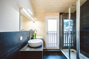 ein Bad mit einer Badewanne, einem Waschbecken und einer Dusche in der Unterkunft Kreischberg Chalets by ALPS RESORTS in Sankt Lorenzen ob Murau