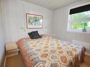 sypialnia z łóżkiem i oknem w obiekcie Holiday Home Gerwin - 3km from the sea in NW Jutland by Interhome w mieście Blokhus
