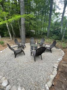 a group of chairs and a table on a gravel patio at MAINE PINES LMIT 8 home in Denmark