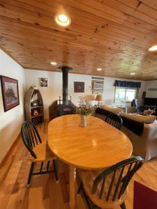 a dining room and living room with a wooden ceiling at TREMONT LIMIT 10 villa in Bridgton