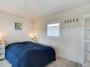 a bedroom with a blue bed and a window at Holiday Home Henric - 100m from the sea by Interhome in Blokhus +13 photos