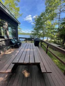 a wooden deck with a bench on a house at HIGHLAND HOLIDAY LIMIT 7-10 cottage in Bridgton