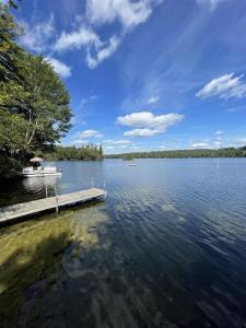 a boat is docked at a dock on a lake at HIGHLAND HOLIDAY LIMIT 7-10 cottage in Bridgton