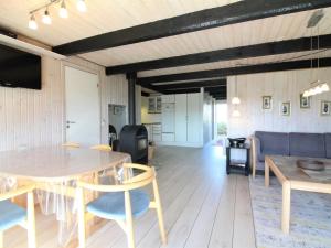 een woonkamer met een tafel en een bank bij Holiday Home Arita - 250m from the sea in NW Jutland by Interhome in Saltum