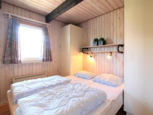 een slaapkamer met een groot wit bed en een raam bij Holiday Home Arita - 250m from the sea in NW Jutland by Interhome in Saltum