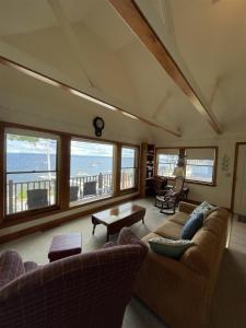 a living room with couches and a view of the ocean at LOON LODGE LIMIT 8 home in Standish