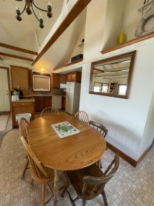 a kitchen and dining room with a wooden table and chairs at LOON LODGE LIMIT 8 home in Standish