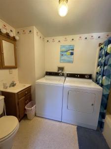 a small bathroom with a washer and dryer in it at LOON LODGE LIMIT 8 home in Standish