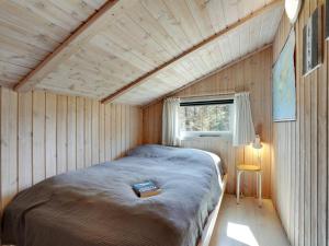 a bed in a small room with a window at Holiday Home Akka - 2km from the sea by Interhome in Saltum +12 photos