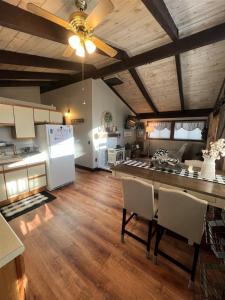 uma cozinha com uma mesa com cadeiras e um frigorífico em ALPINE VILLAGE GETAWAY LIMIT 8 cottage em Bridgton