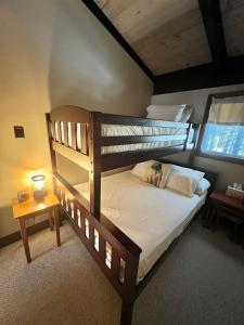 a bedroom with two bunk beds and a table at ALPINE VILLAGE GETAWAY LIMIT 8 cottage in Bridgton