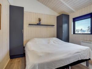 een slaapkamer met een bed in een kamer met een raam bij Holiday Home Hildegard - 1-5km from the sea in NW Jutland by Interhome in Hjørring