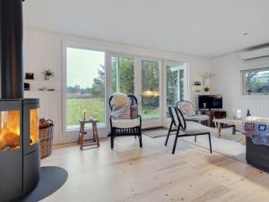 sala de estar con sillas y chimenea en Holiday Home Ayelen - 600m from the sea in NW Jutland by Interhome, en Saltum