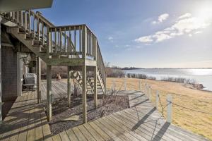 a house with a wooden staircase leading down to a beach at Rhode Island Retreat with Kayaks, Deck and Pond Access in South Kingstown