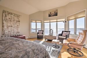 a bedroom with a bed and chairs and windows at Rhode Island Retreat with Kayaks, Deck and Pond Access in South Kingstown