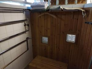 a bathroom with a wooden paneled shower with a wooden floor at Veikkola Karstula in Karstula