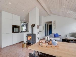 a kitchen and living room with a wood stove at Holiday Home Kadife - 750m from the sea in NW Jutland by Interhome in Saltum