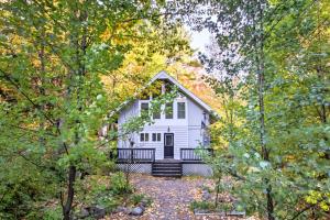 una casa bianca in mezzo al bosco di Gilford Cabin - 2 Mi to Gunstock Mountain Resort! a Gilford