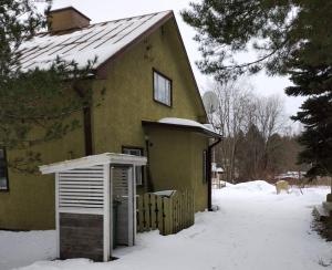 une maison jaune avec de la neige au sol dans l'établissement Veikkola Karstula, à Karstula