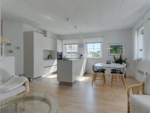 cocina y sala de estar con mesa y sillas en Apartment Cornel - 400m from the sea in NW Jutland by Interhome, en Hjørring