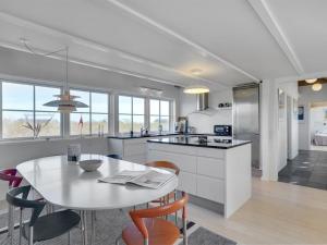 - une cuisine avec une table, des chaises, une table et un comptoir dans l'établissement Holiday Home Galin - 200m from the sea in NW Jutland by Interhome, à Hjørring
