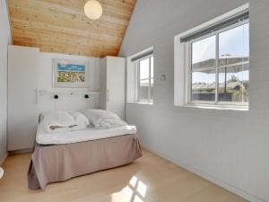 een slaapkamer met een bed in een kamer met een raam bij Holiday Home Galin - 200m from the sea in NW Jutland by Interhome in Hjørring
