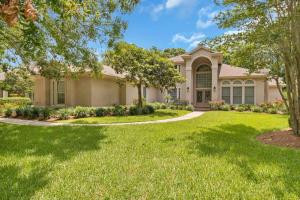 a house with a green lawn and trees at Club Views - Pool Home in Ponte Vedra Beach