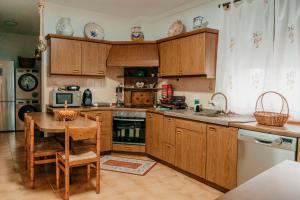 a kitchen with wooden cabinets and a wooden table and a tableablish at Casa Capricho del Destino in Villatobas