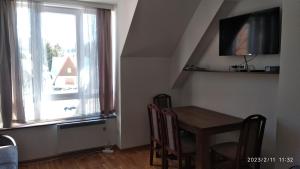 a dining room with a table and a window at Apartman Studio Lux u Kraljevim Čardacima in Kopaonik +49 photos