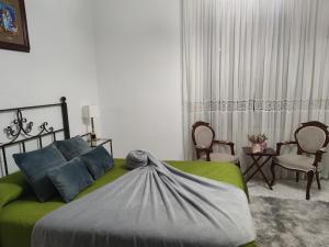 a bedroom with a green bed and a table and chairs at Casa Capricho del Destino 
