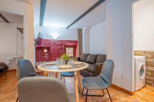 ein Wohnzimmer mit einem Tisch, Stühlen und einem Sofa in der Unterkunft Apartamento 1 en la muralla romana junto a la Catedral in Tarragona