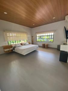 een grote slaapkamer met een bed en 2 ramen bij Casa Finca Soluna in Cumaral