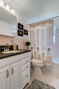 Un baño con inodoro, lavabo y cortina de ducha. en Shady Oaks, en Jacksonville Beach