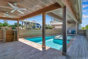 a house with a swimming pool and a wooden deck at Salt Therapy North and South in Saint Augustine