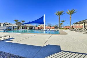 a swimming pool with a blue tent and palm trees at Patio and Balcony Spacious Gilbert Getaway! in Gilbert