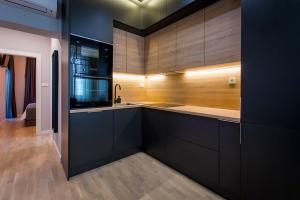 a kitchen with black cabinets and a sink and a counter at Emar Apartment - old town center in Zadar