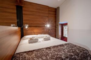 a bedroom with a large bed with a wooden wall at Apartamento 1 en la muralla romana junto a la Catedral in Tarragona